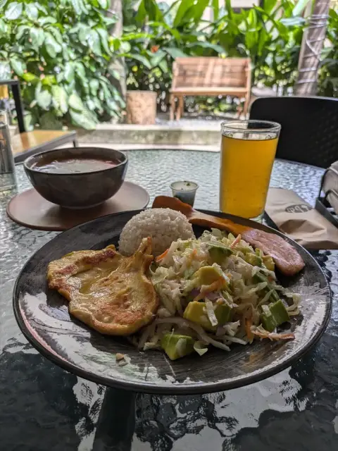 Plato de pollo con arroz, ensalada y aguacate, con sopa y jugo