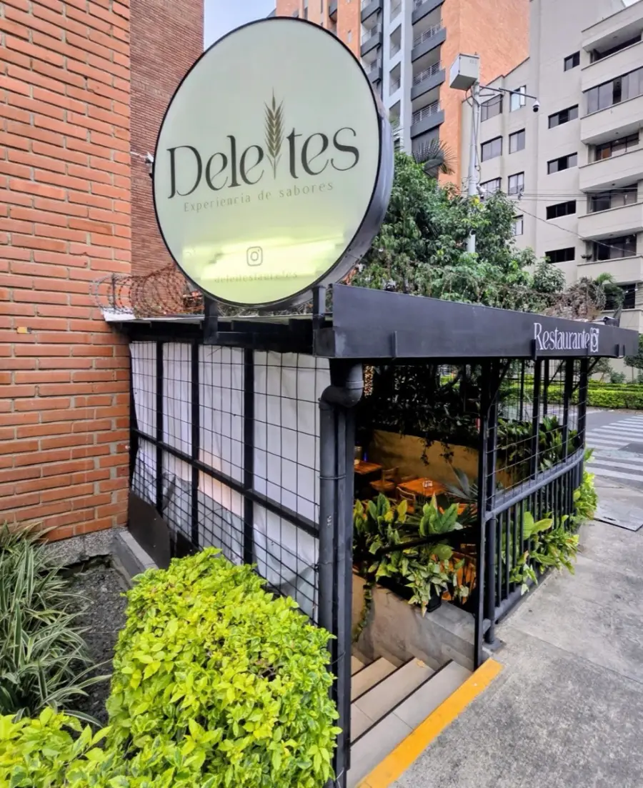 Entrada de Panadería Deleites con su aviso y plantas