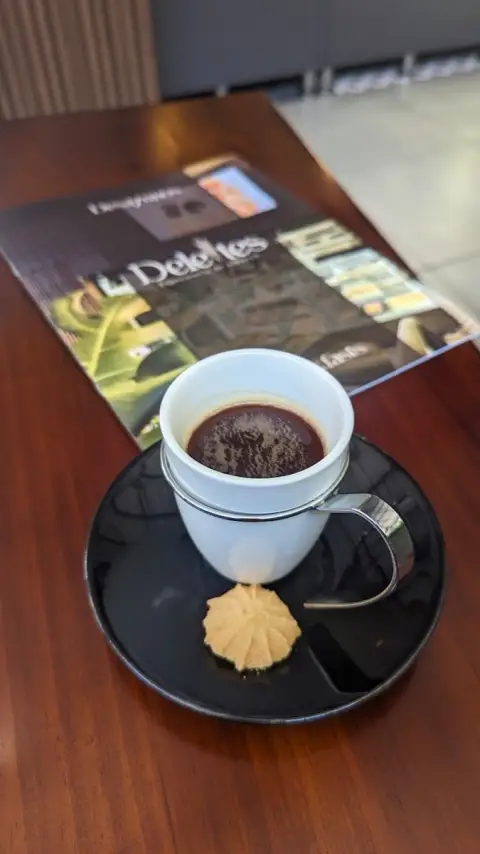 Tinto con galleta junto a la carta de Deleites